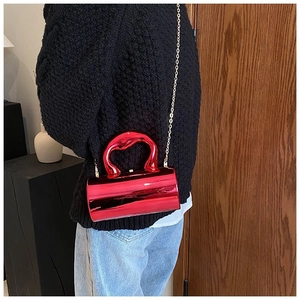 Detail of red cylindrical mirror bag with unique wave handle and gold chain strap
