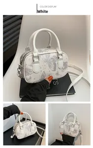 Detail view of white butterfly print PU leather boston bag with adjustable straps