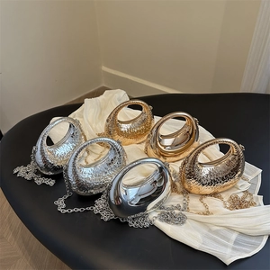 Metallic acrylic clutch bags with honeycomb textures and round handles on soft fabric