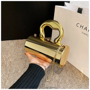 Detail of golden mirror cylindrical box bag with unique thick handle and chain strap