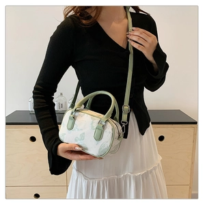 Floral Boston handbag with double handles and adjustable strap worn as a crossbody bag