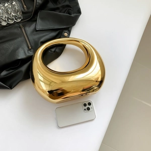 Sac à main ovale doré métallique avec effet miroir et poignée intégrée pour les soirées chics