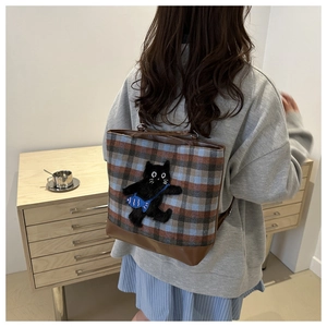 Detail of plaid wool tote bag with cartoon cat embroidery and brown leather straps