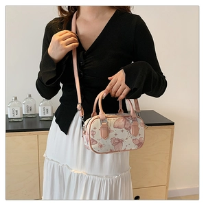 Detailed view of butterfly print boston bag worn as a crossbody on a female model