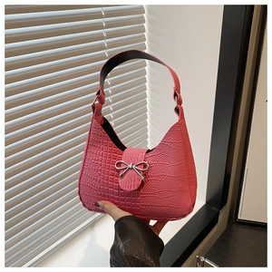Dettaglio borsa in pelle coccodrillo rosa con fibbia a fiocco in metallo argentato