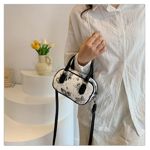 Detail of mini cylindrical Boston bag with butterfly print and adjustable shoulder strap