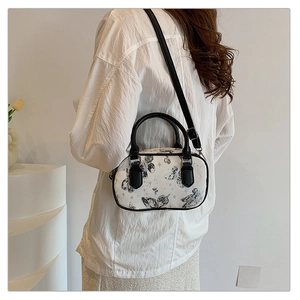 Mini cylindrical shoulder bag with butterfly print shown on model in white shirt