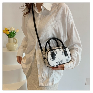 Chic Boston bag with butterfly print shown on a model in a minimalist studio setting