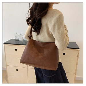 Detailed view of the dark brown patchwork tote bag with stylish knotted shoulder strap