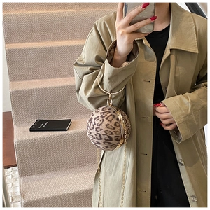 Detail of leopard print sphere bag with rhinestone handle and golden chain strap