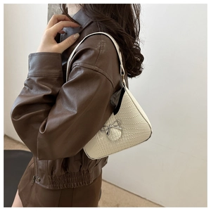 Détail du sac à bandoulière blanc à motif crocodile avec nœud en métal argenté