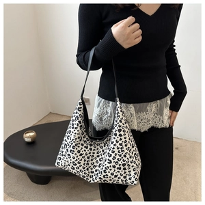 Vue détaillée du sac cabas en toile à imprimé léopard noir et blanc avec bandoulière noire