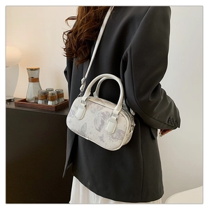 Detailed side view of white pillow bag with purple butterfly print on model in black suit