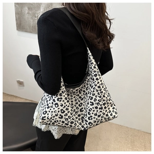 Hobo shoulder bag featuring black and white leopard print worn by a model in profile