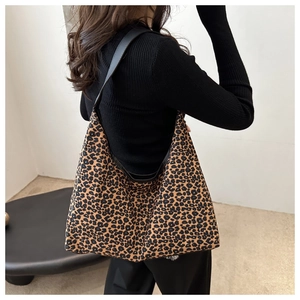 Detail view of stylish leopard print hobo bag with wide black shoulder strap for women