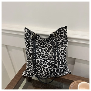 Detalle del bolso tote grande con estampado de leopardo y correas negras dobles