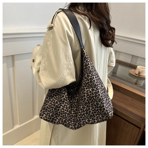 Detail of leopard print hobo bag with dark leather strap shown on model in trench coat