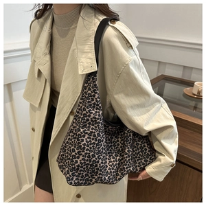 Détail du sac à bandoulière hobo en toile imprimé léopard avec large sangle noire