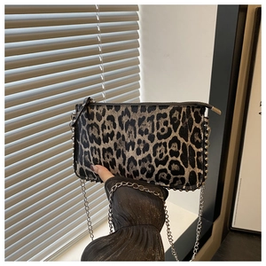 Close-up of leopard print crossbody bag with silver rivet studs and sleek metal chain