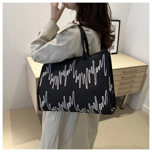 Détail du sac cabas brodé noir avec surpiqûres ondulées colorées et texture diamant