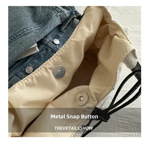 Detail shot of the magnetic clasp on the light beige inner lining of the bucket bag