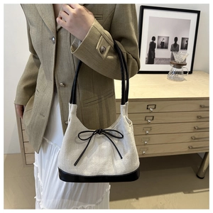Minimalist white herringbone tote bag with black leather straps and decorative bow detail