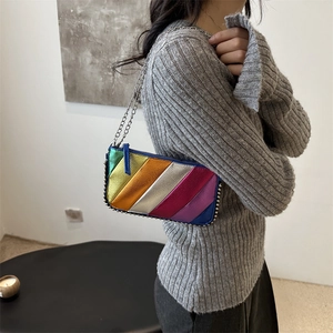 Rainbow striped crossbody bag with silver chain strap and metallic finish on shoulder