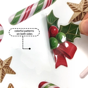 Close-up of double-sided Christmas stickers with candy canes and holly on window
