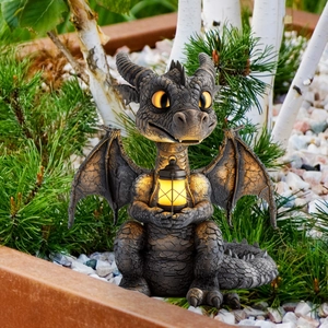 Macro detail of cartoon dragon garden statue holding a warm solar lantern decoration
