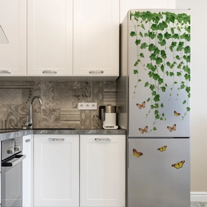 Detail of green ivy vine wall stickers with orange butterflies on a silver refrigerator
