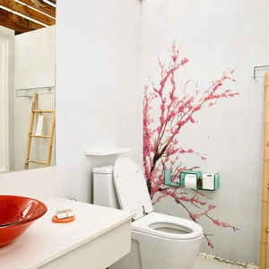 Close-up of pink cherry blossom wall stickers on a white tiled wall in a modern bathroom