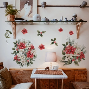 Close-up of red poinsettia and green leaf wall stickers on a white interior wall
