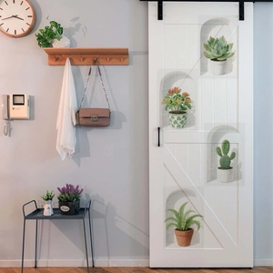 Detailed view of 3D potted green plant wall stickers on a modern white barn door