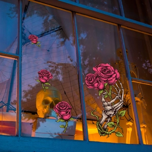 Halloween window stickers with gothic skull hand and vibrant pink roses for decoration