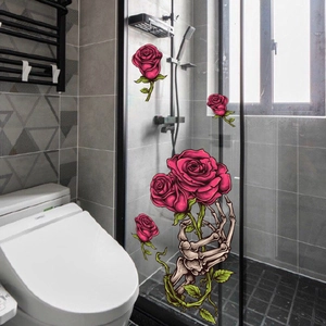 Detail of gothic skull hand holding red roses static cling window sticker on bathroom glass