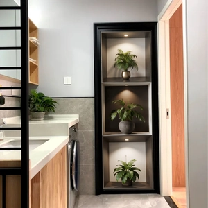 Detail view of a 3-tier black wall niche with warm LED lighting and green plants