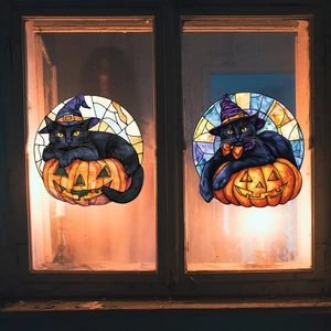 Detail von Fensterbildern im Buntglas-Stil mit Katzen- und Kürbismotiv bei Beleuchtung