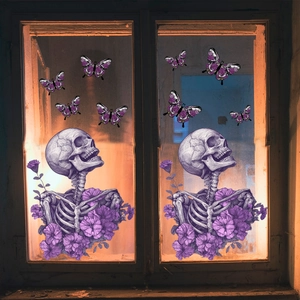 Detail of gothic window clings with purple skull flowers and butterflies on glass
