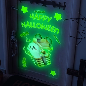 Close-up of luminous Halloween ghost and stars sticker glowing bright green in the dark