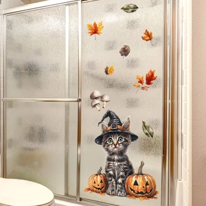 Detail von Halloween Fensterbild mit getigerter Katze, Hexenhut und Kürbis auf Glas