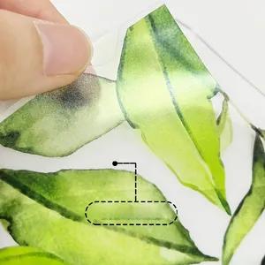 Detail of self-adhesive watercolor green leaf wall decal being peeled from the backing