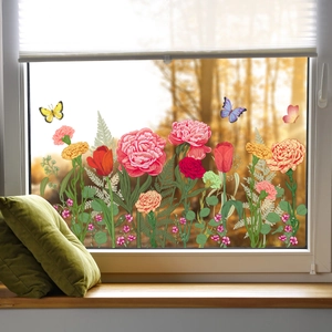 Detailed view of pink floral and butterfly window stickers on glass with a garden background