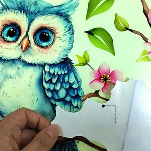 Détail d'autocollant mural hibou phosphorescent montrant le support adhésif en PVC de qualité