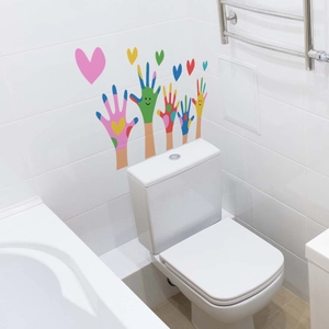 Colorful handprint and heart wall stickers on a white bathroom tile wall