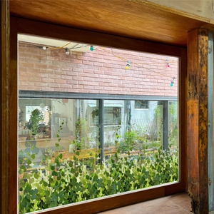 Detail of green vine window decals showing lifelike leaves on a sunlit glass pane