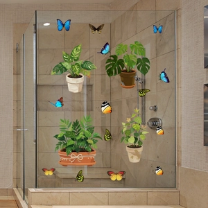 Detail of green potted plant and butterfly window stickers on shower glass door