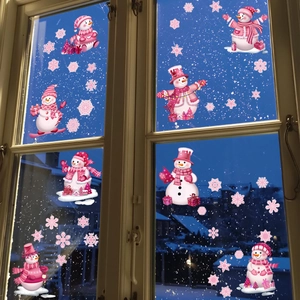 Pink snowman and snowflake static window clings on glass with snowy night scene background