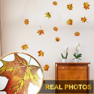 Détail de stickers muraux feuilles d'érable peints à la main avec bords dorés sur mur chaud