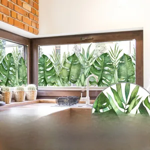 Detail of tropical monstera leaf static cling sticker on a kitchen window pane