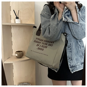 Selfie miroir montrant un grand sac cabas en toile gris clair avec lettrage artistique